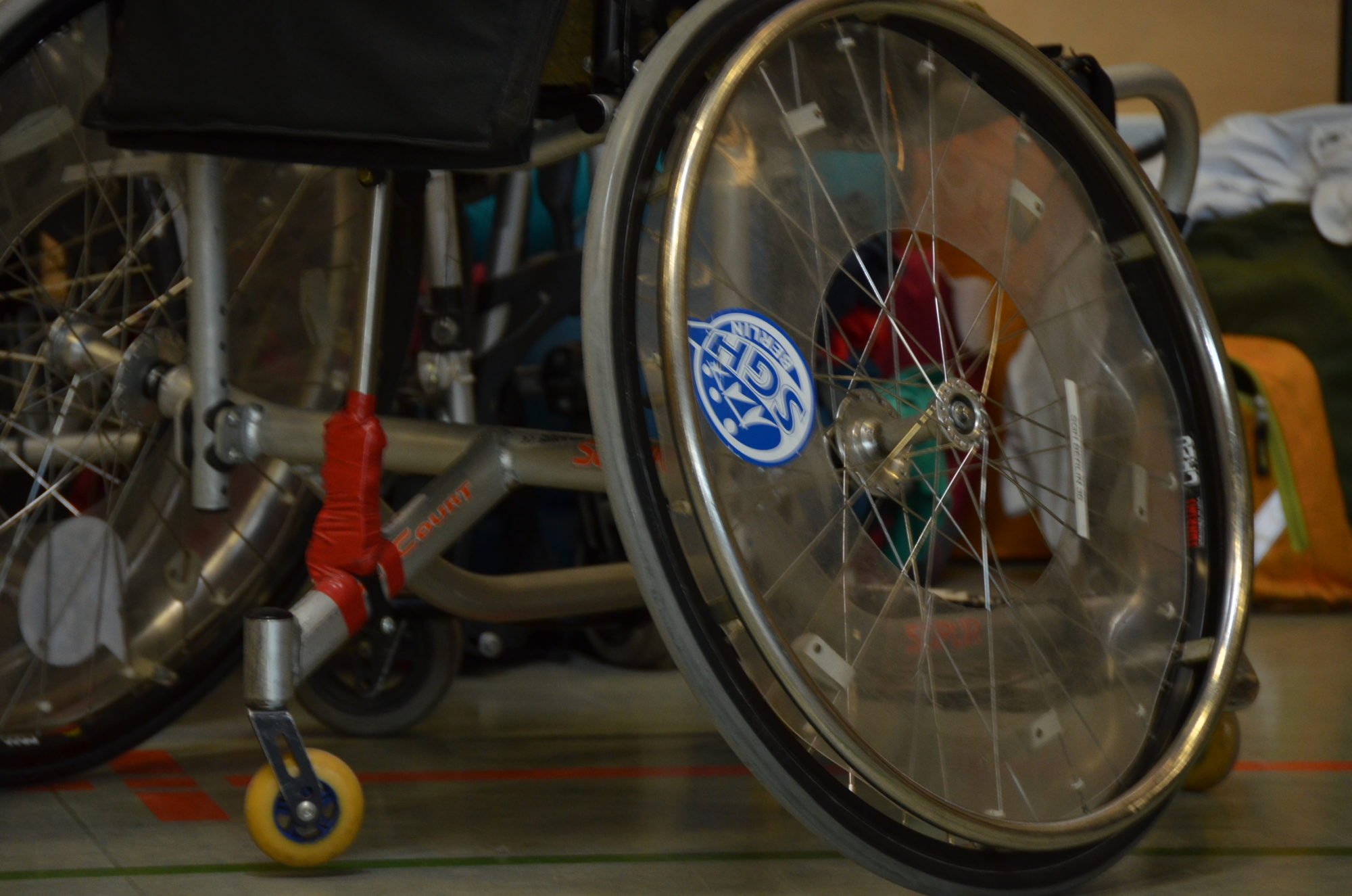 Nahaufnahme eines Rollstuhl-Rades mit SGH Aufkleber.