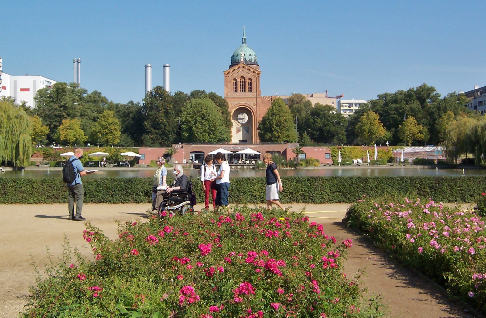 Blumenbeete am Luisenstädtischen Kanal mit einer Spaziergruppe im Rolli