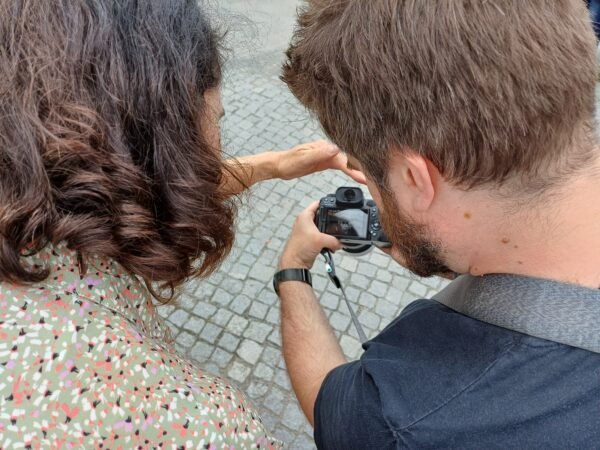 Eine Frau und ein Mann schauen sich Fotos auf einer Kamera an