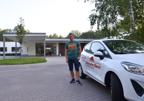 Pflegefachkraft Marco Noack mit einem AD-Auto vor dem P.A.N. Zentrum