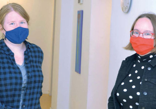 Zwei FRauen mit Mundnasenschutz schauen in die Kamera