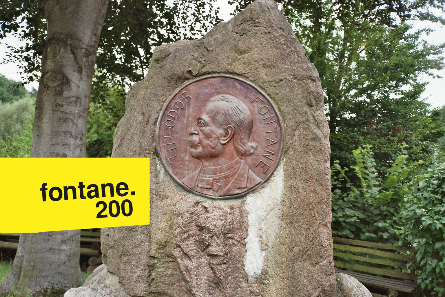Denkmal mit Theodor Fontane im Profil. Eine Treibarbeit, die in Falkenberg steht. Mit in das Bild montiert: das Logo des Fontanejahres: "fontane. 200" in schwarzer Schrift auf gelben Grund.