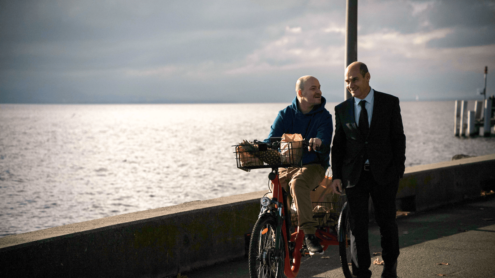 EIn Radfahrer und ein Fußgänger auf einer Uferpromenade