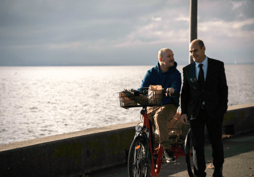 EIn Radfahrer und ein Fußgänger auf einer Uferpromenade