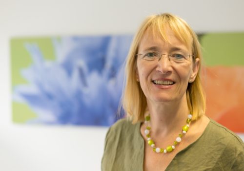 Bild von Frau Hundertmark-Mayser: Eine blonde Frau mit schulterlangen Haaren und Brille. Sie trägt eine Kette sowie ein grünes Oberteil.