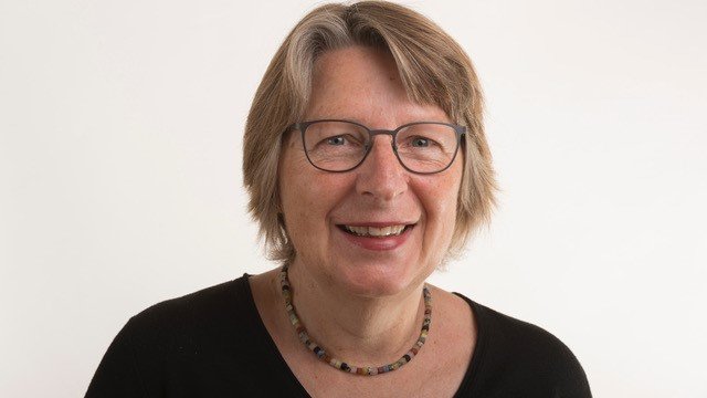 Porträtfoto von Annemarie Kühnen-Hurlin - eine Frau fortgeschrittenen Alters, mit halblangen blonden Haaren und Brille.