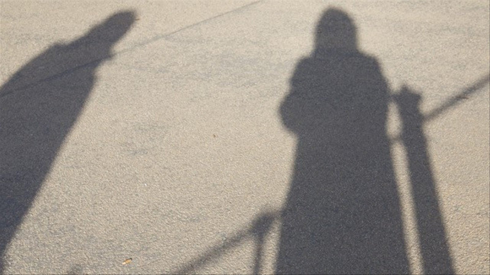 Zwei Schatten auf dem Asphalt