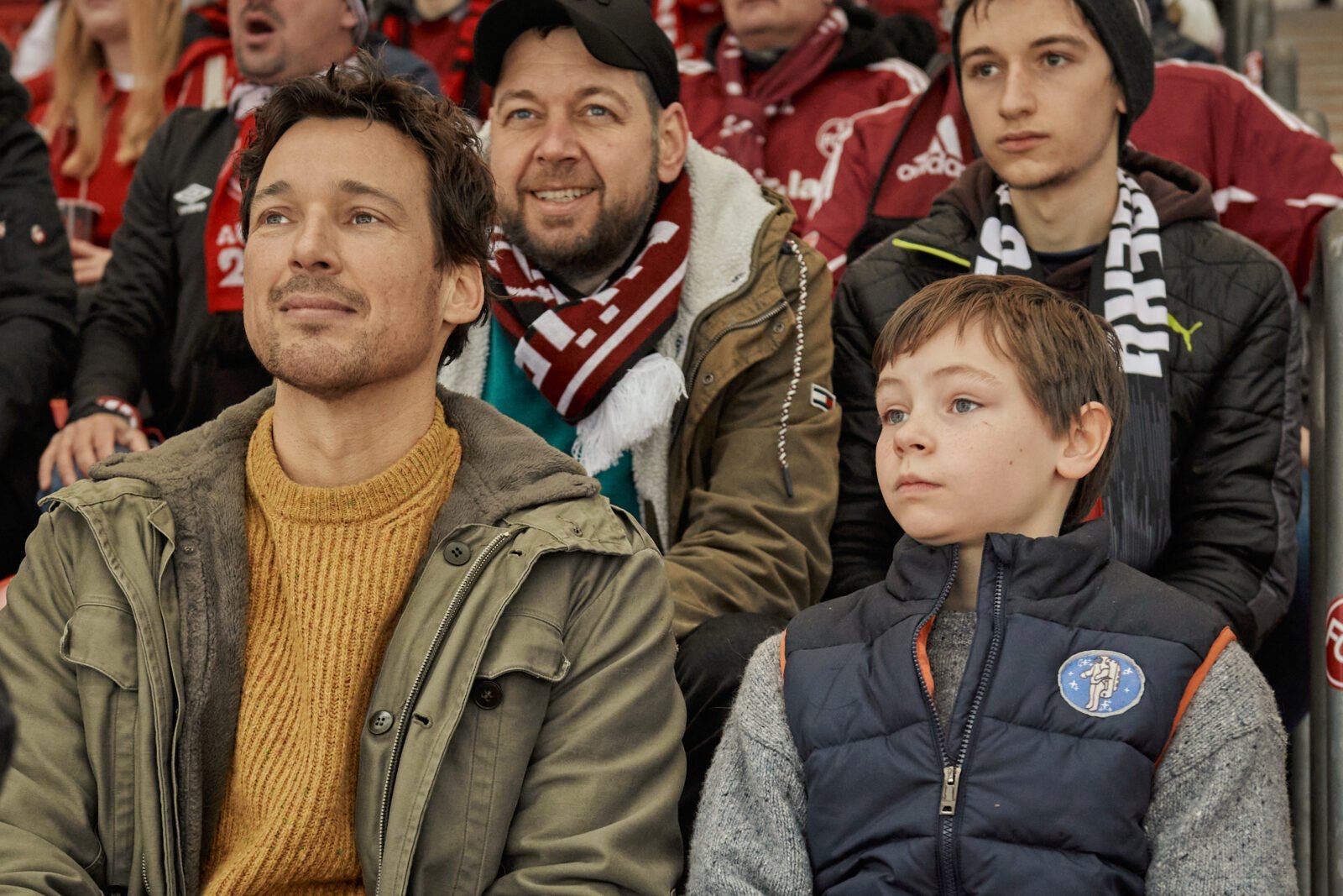 Bild einer Szene aus dem Film Wochenendrebellen: Vater und Sohn sitzen im Stadion.
