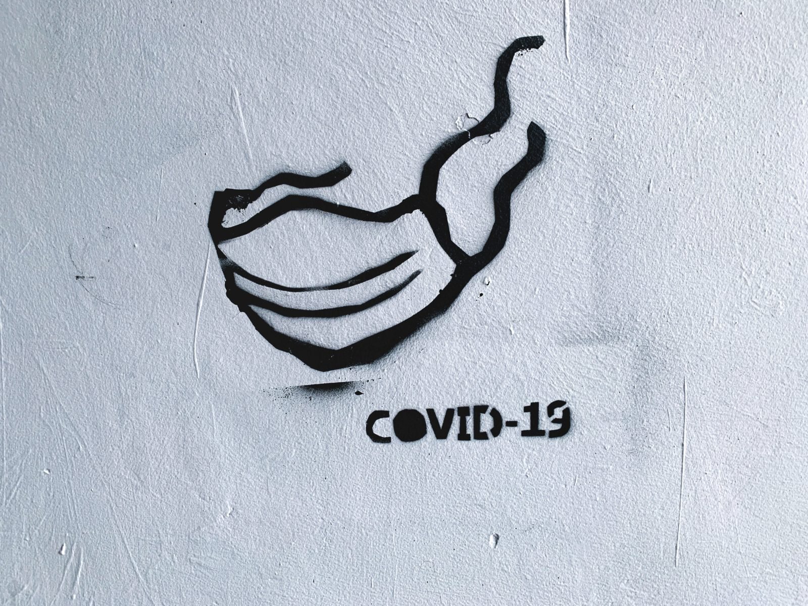 Schablonenkunst mit einem Mundschutz und der Aufschrift COVID-19