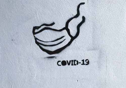 Schablonenkunst mit einem Mundschutz und der Aufschrift COVID-19