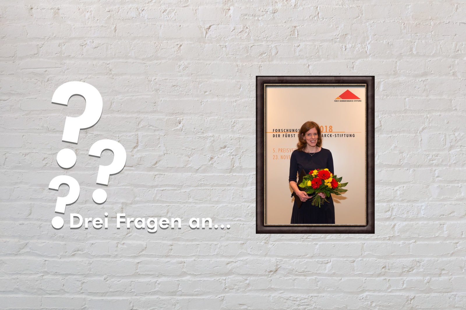 Zu sehen ist ein Bild von Sonja Suntrup-Krüger auf der Verleihung des Forschungspreis 2018 sowie drei Fragezeichen und der Titel "Drei Fragen an"
