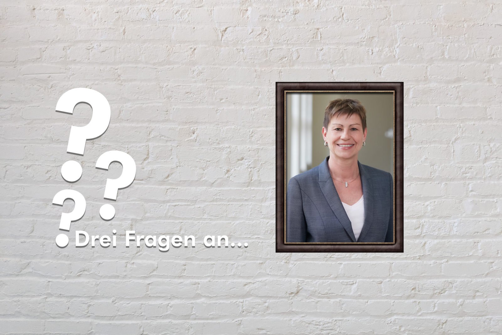 Fotomontage: Eine weiße Steinwand - darauf ein Rahmen, in den ein Bild von Elke Breitenbach montiert ist, daneben der Schriftzug Drei Fragen an... und drei Fragezeichen.