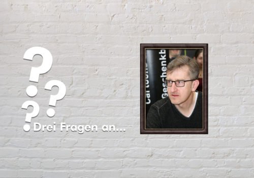 Fotomontage: Eine weiße Steinwand - darauf ein Rahmen, in den ein Bild von Phil Hubbe montiert ist, daneben der Schriftzug Drei Fragen an... und drei Fragezeichen.