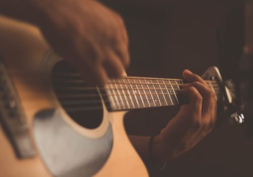Nahaufnahme: Akustikgitarre, die gerade bespielt wird.