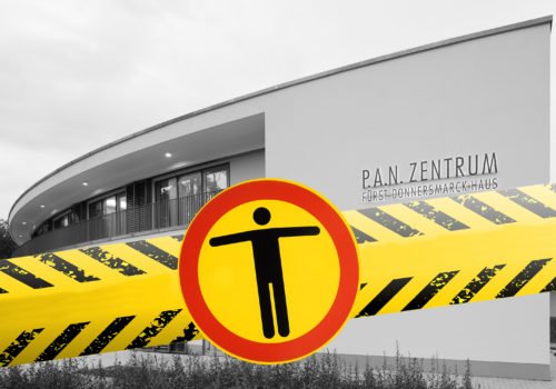 Schwarz-Weiß-Bild des P.A.N.Zentrums - ins Bild montiert eine gelb-schwarzes Band und einem Piktogramm "Zugang verboten"