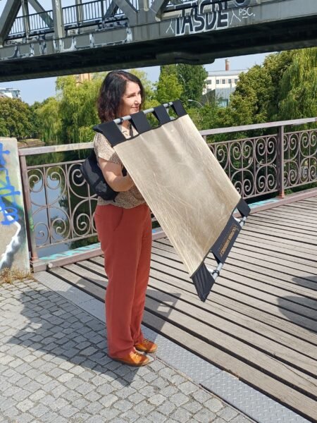 Eine Frau steht auf einer Brücke und hält einen Reflektor
