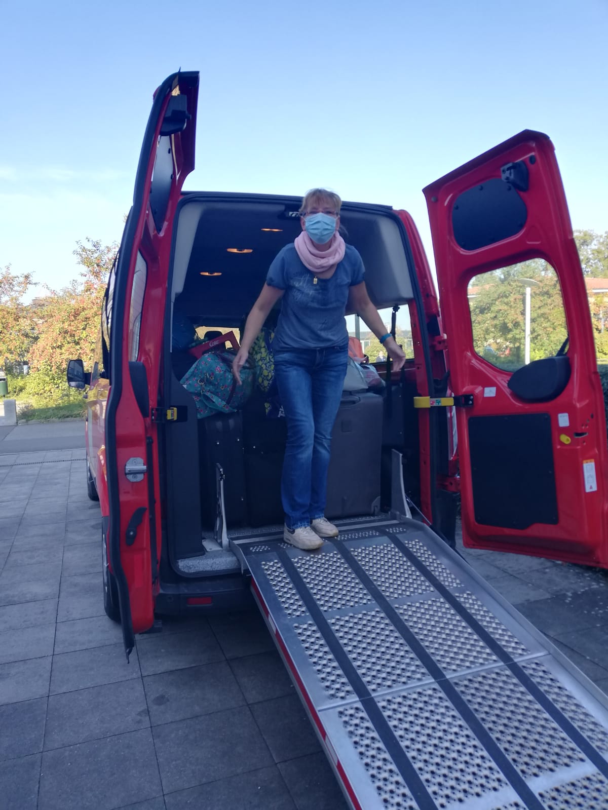 Michaela Ruhp, Alltagsmaske tragend, steht auf der Rollstuhlrampe eines Kleinbusses.