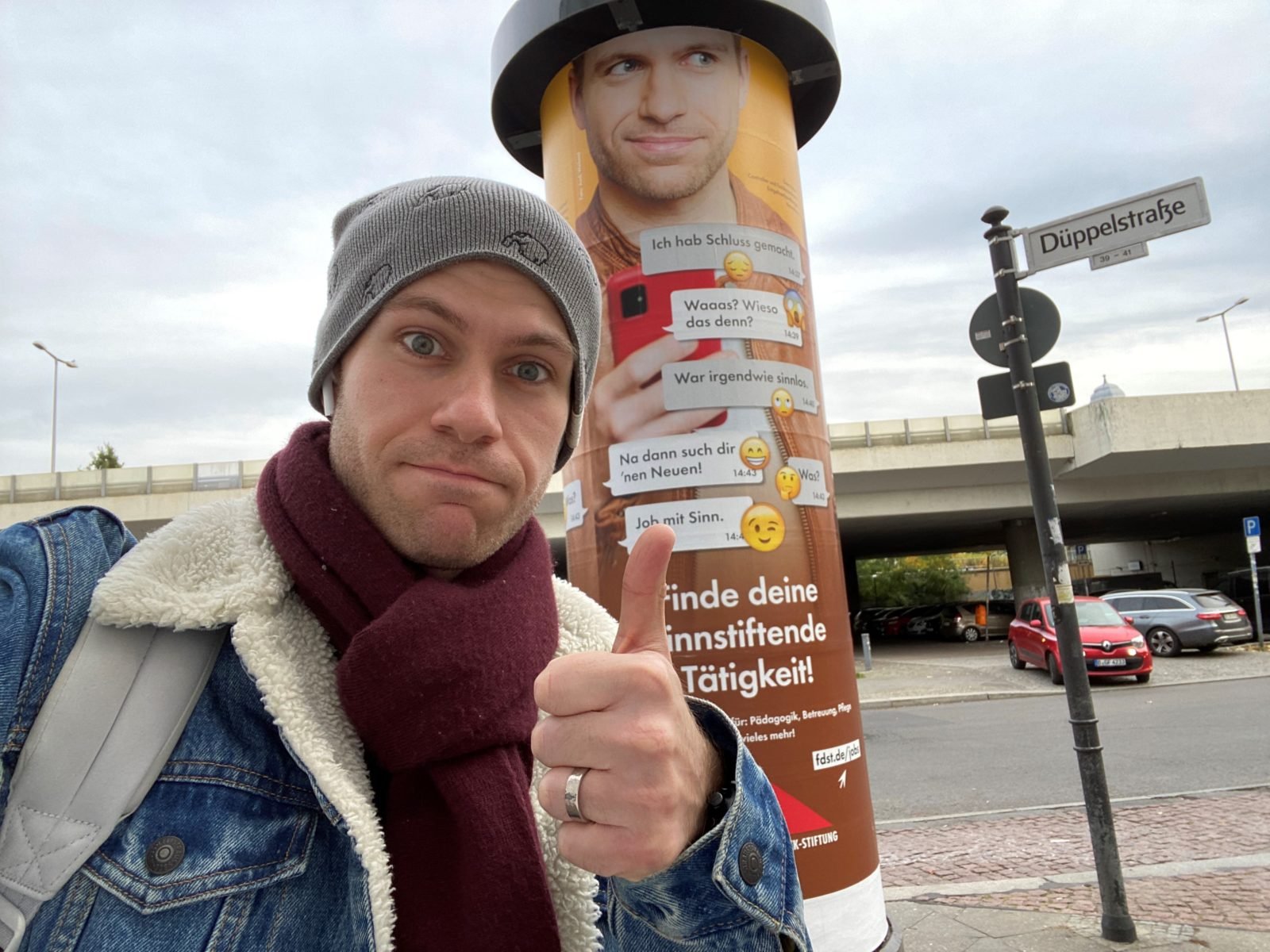 Sven Rubert vor einer Litfaßsäule mit der Werbung, für die er Modell stand.