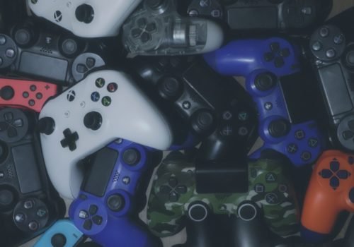 Ein großer Haufen bunter Controller unterschiedlicher Spielekonsolen und Hersteller.