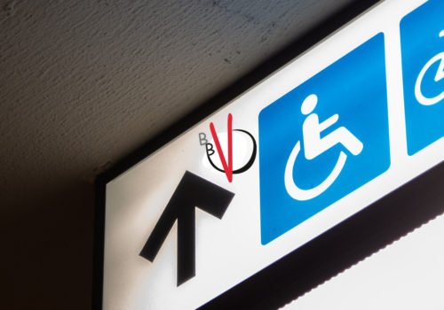Ein Schild mit einem Pfeil nach vorne, daneben das Piktogramm eines Rollstuhlfahrer. In das Bild eingeklinkt das Logo des BBV.